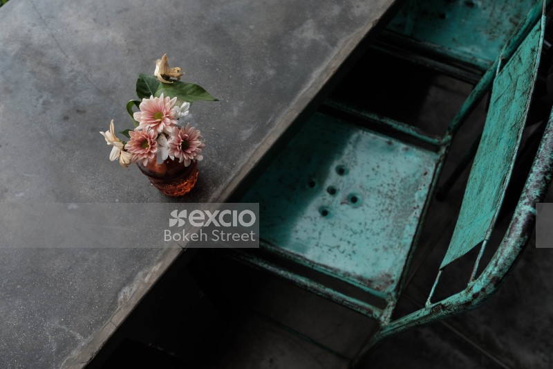Flowers in a vase on table and old chair