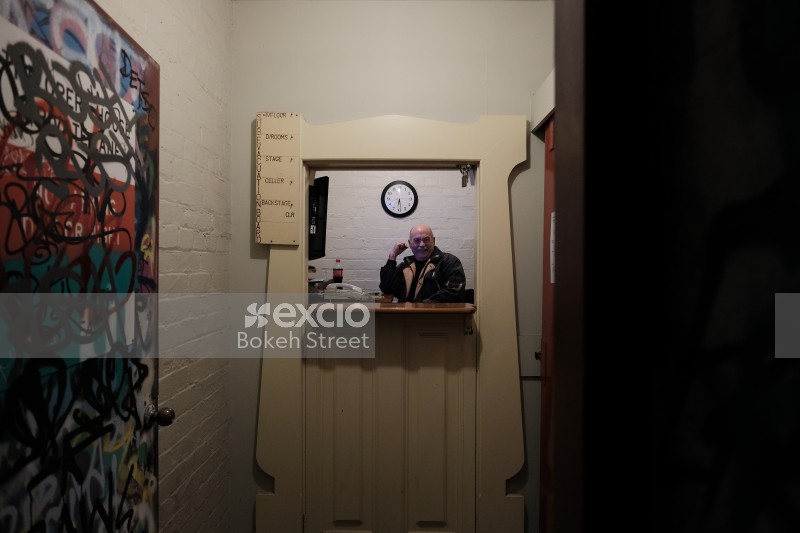 Old bald man inside a building with split door