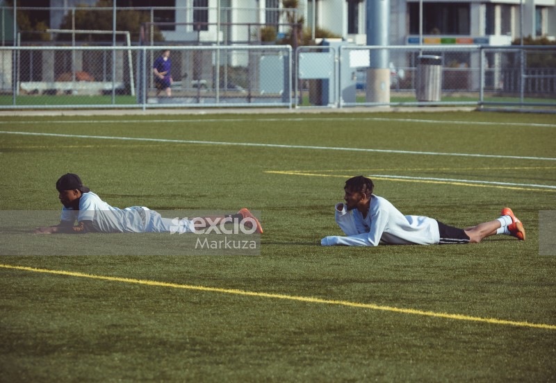 Two athletes lying on their bellies in the field - Sports Zone sunday league