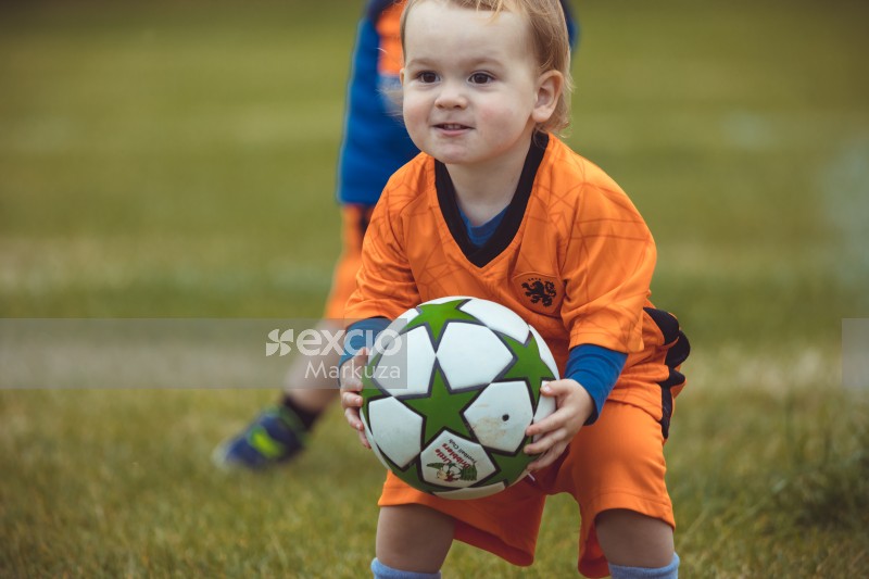 Kid in Netherland kit holding football - Little Dribblers