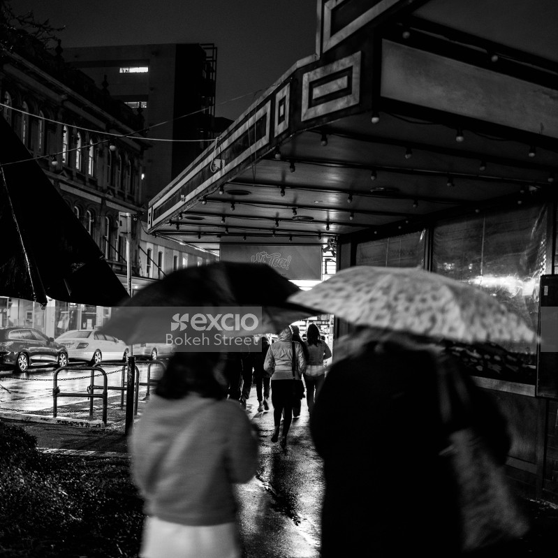 People in rainy night in the street black and white