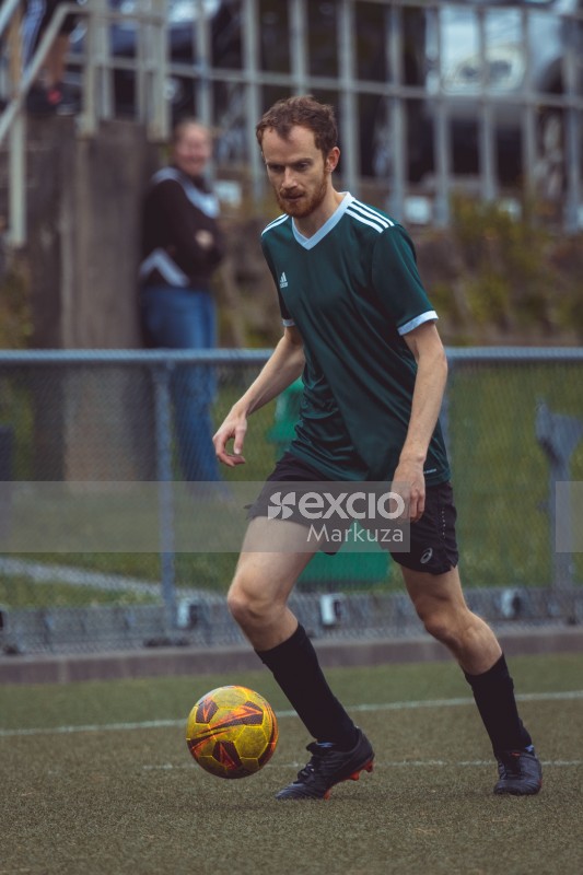 Thin football player wearing green Adidas shirt - Sports Zone sunday league