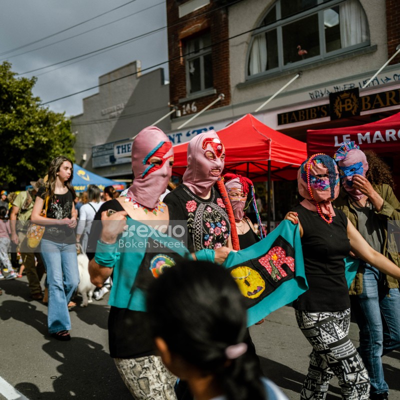 Women in masks hold a banner at Newtown festival 2021