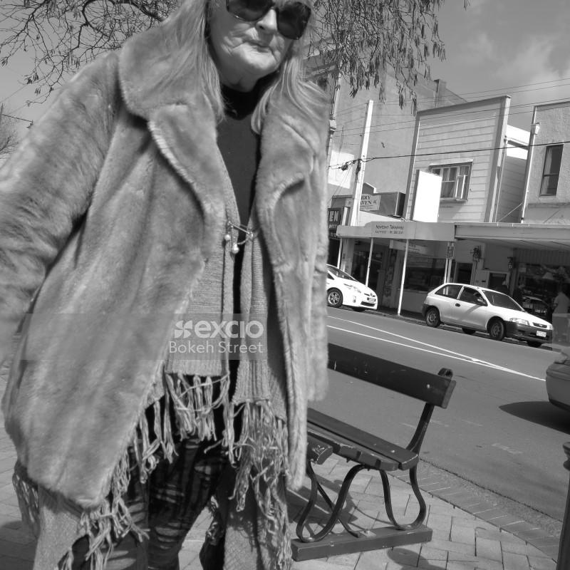 Old lady in a poncho and fur coat in the street in Newtown monochrome