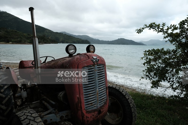 Old red Massey Ferguson 35 tractor at a beach in Raetihi