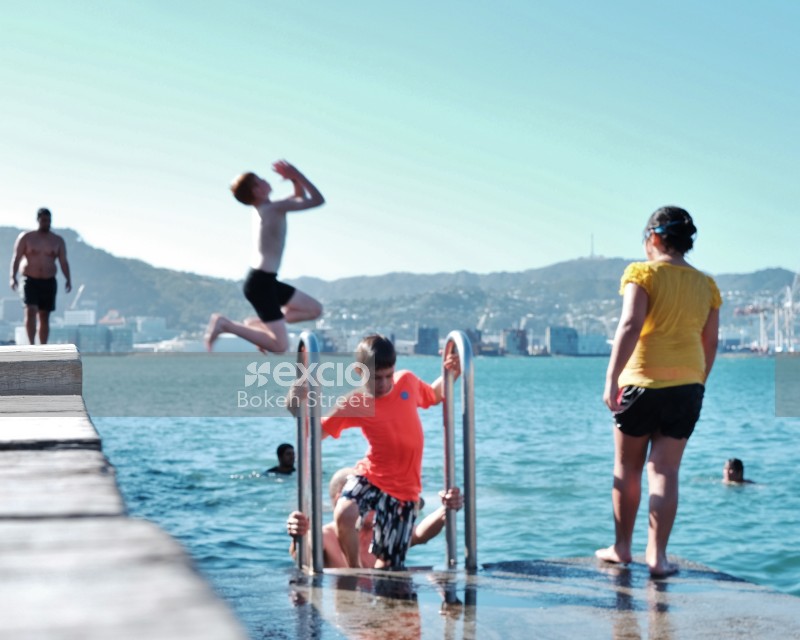 Kids diving into water from the pier