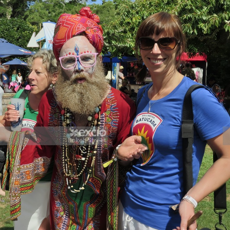 Indian attired man with women wearing blue and green shirt at WOMAD festival