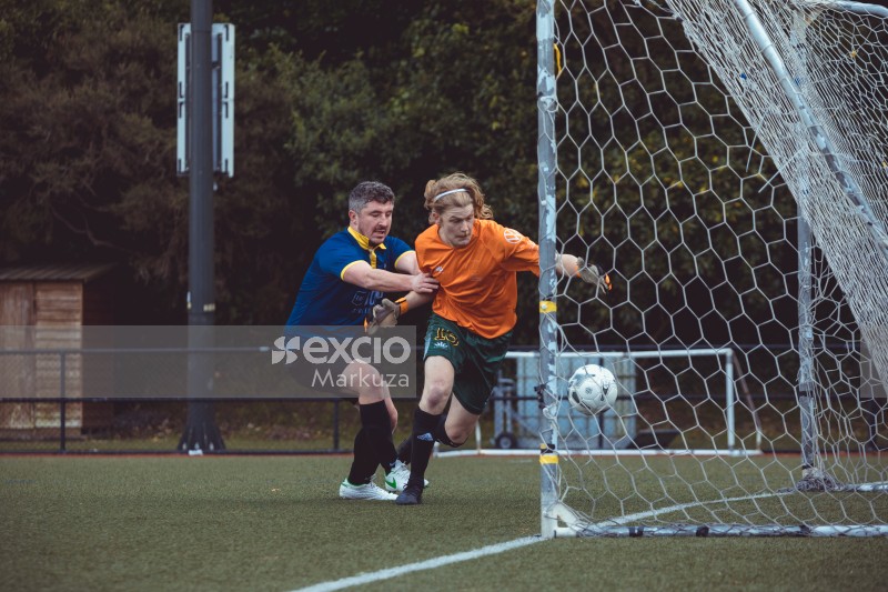 Football player grabs goalkeeper from stopping the ball - Sports Zone sunday league