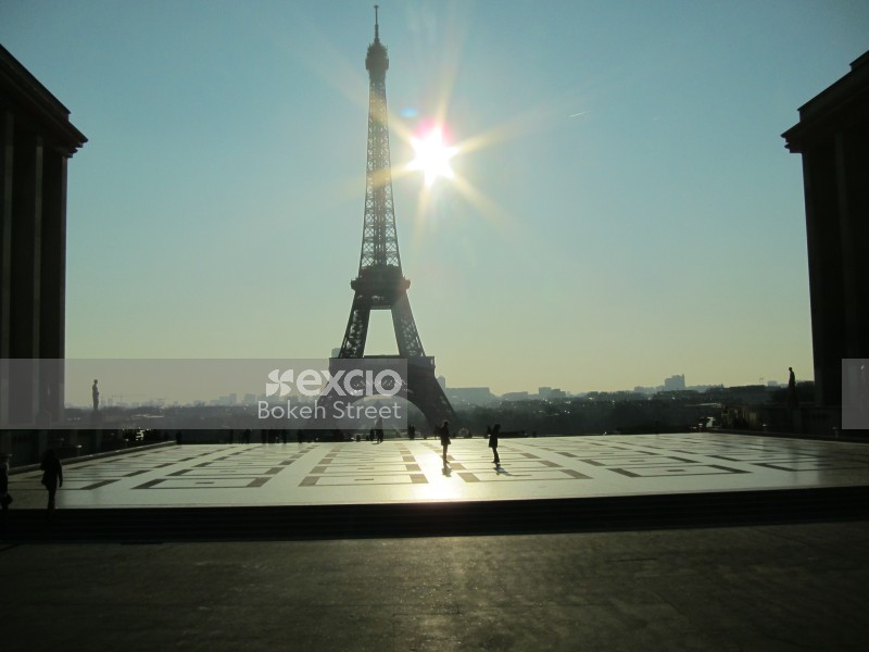 The Eiffel tower and silhouette of people on a sunny day