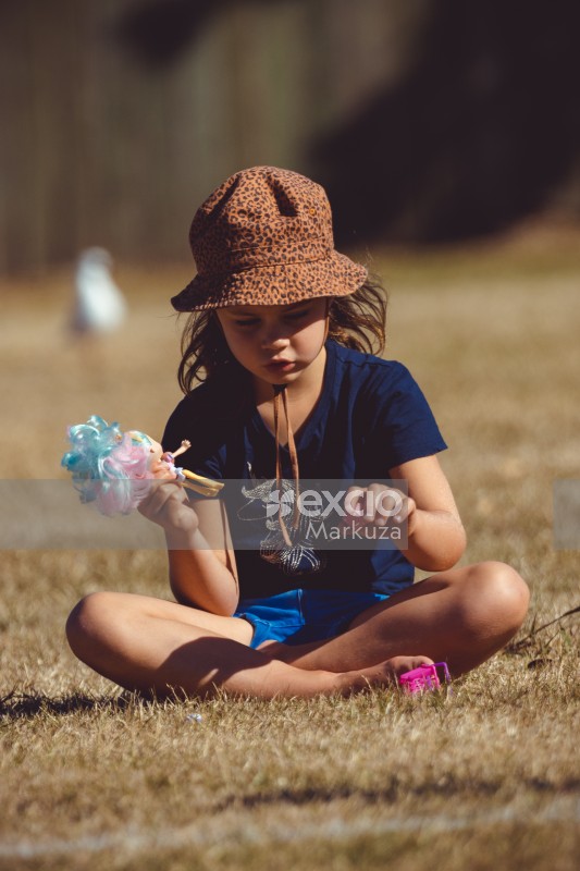 Little girl In leopard print hat blue shirt and shorts playing with a doll - Little Dribblers