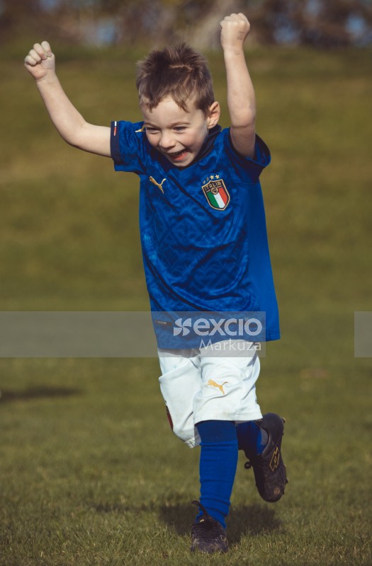 Little boy cheering at Little Dribblers football match