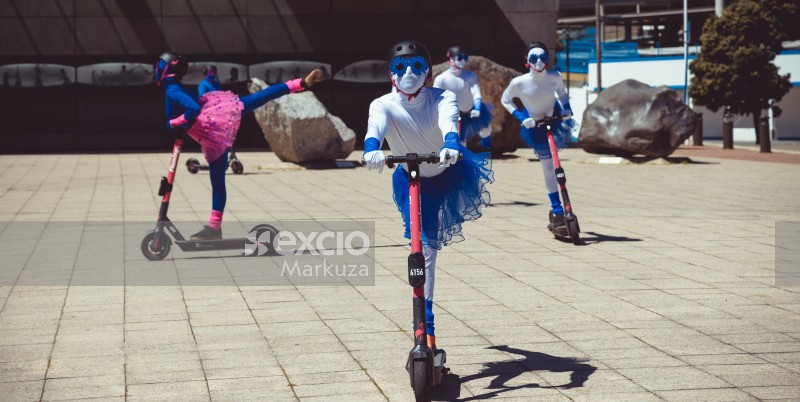 Ballet performers performing ballonne step on scooter