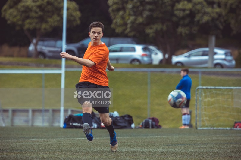 Player in orange shirt kicks football bokeh - Sports Zone sunday league