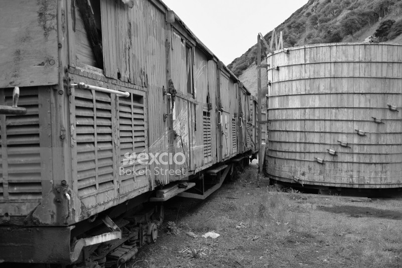 Abandoned old freight bogie and wooden drum structure monochrome