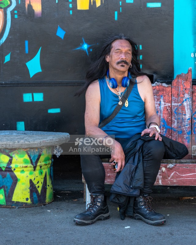 Man with long hair sitting on seat