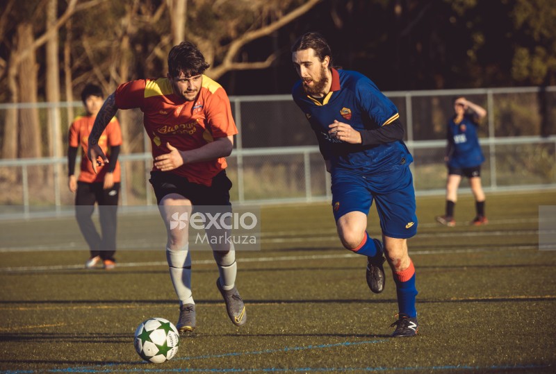 Soccer player racing to reach the ball - Sports Zone sunday league