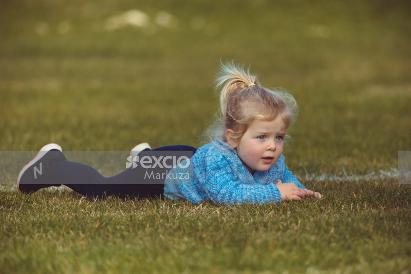 Blue eyed girl laying down on field - Little Dribblers