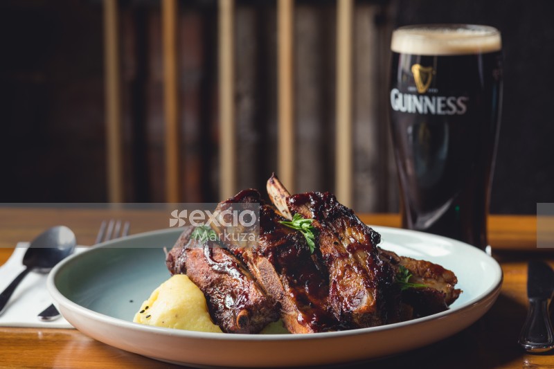Finger licking delicious pork ribs and Guinness stout beer