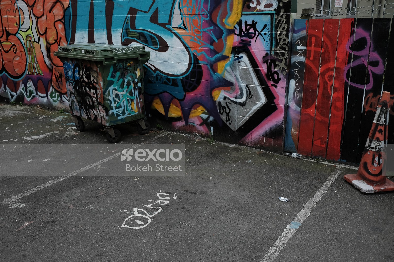 Graffitied wall and trash bin