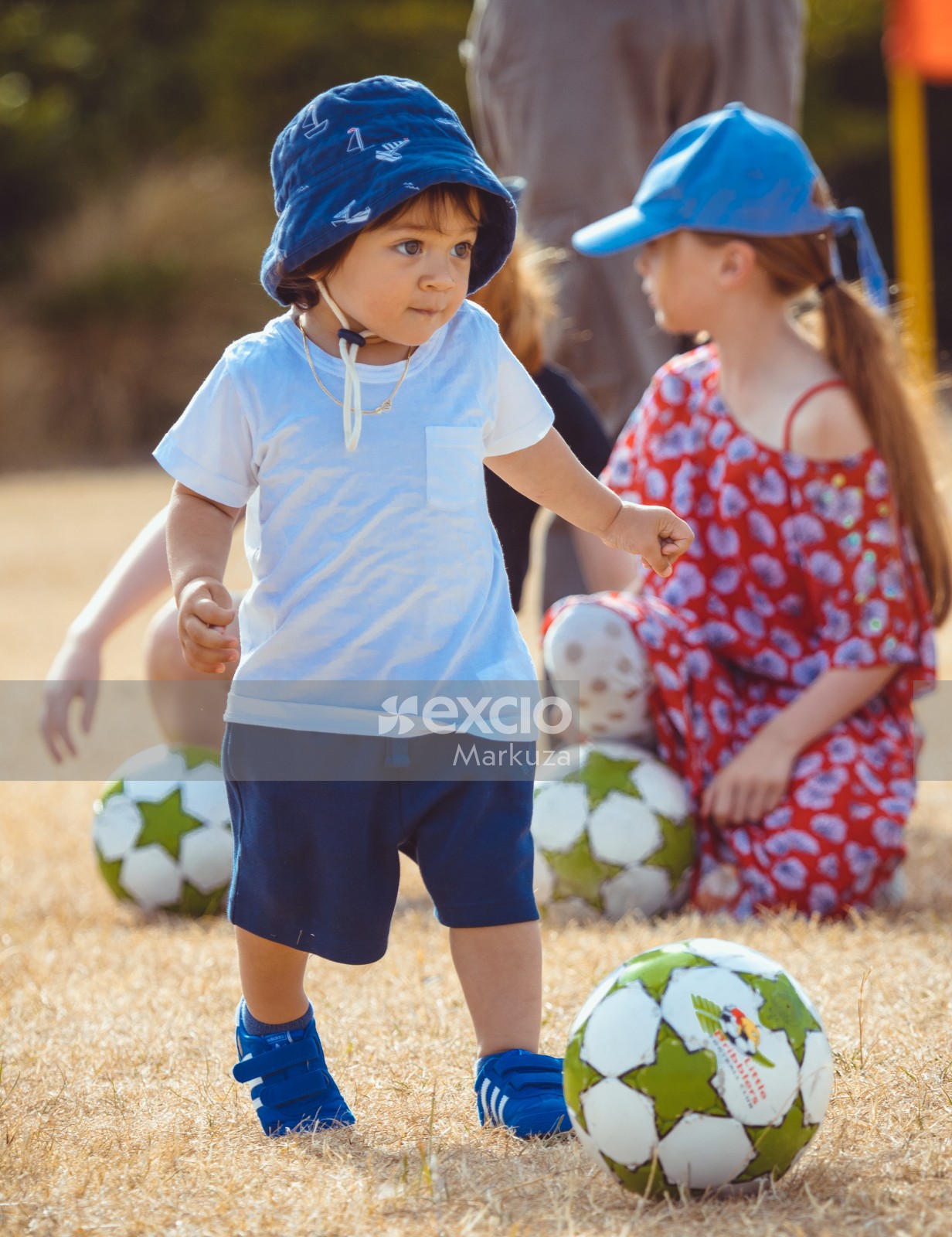 Boy in blue hat shorts shoes and white shirt - Little Dribblers