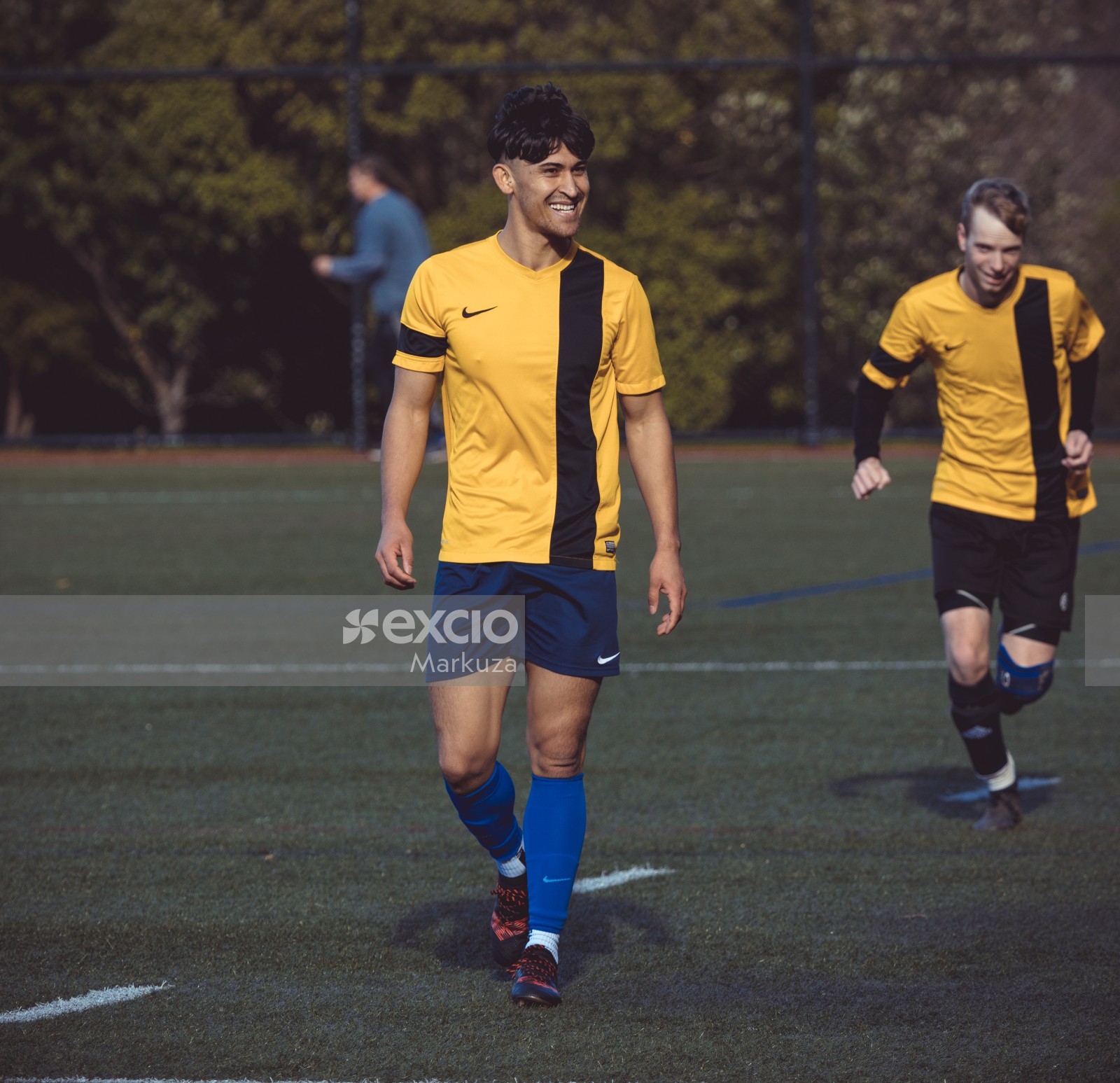 Player in yellow Nike shirt blue shorts and socks smiling - Sports Zone sunday league