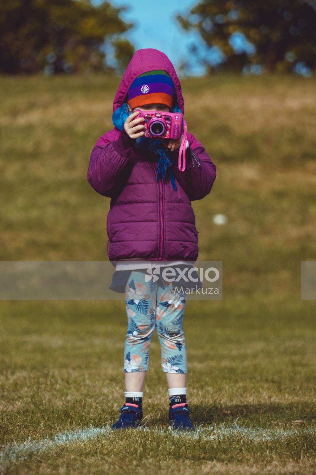 Little girl in purple jacket with a pink toy camera - Little Dribblers