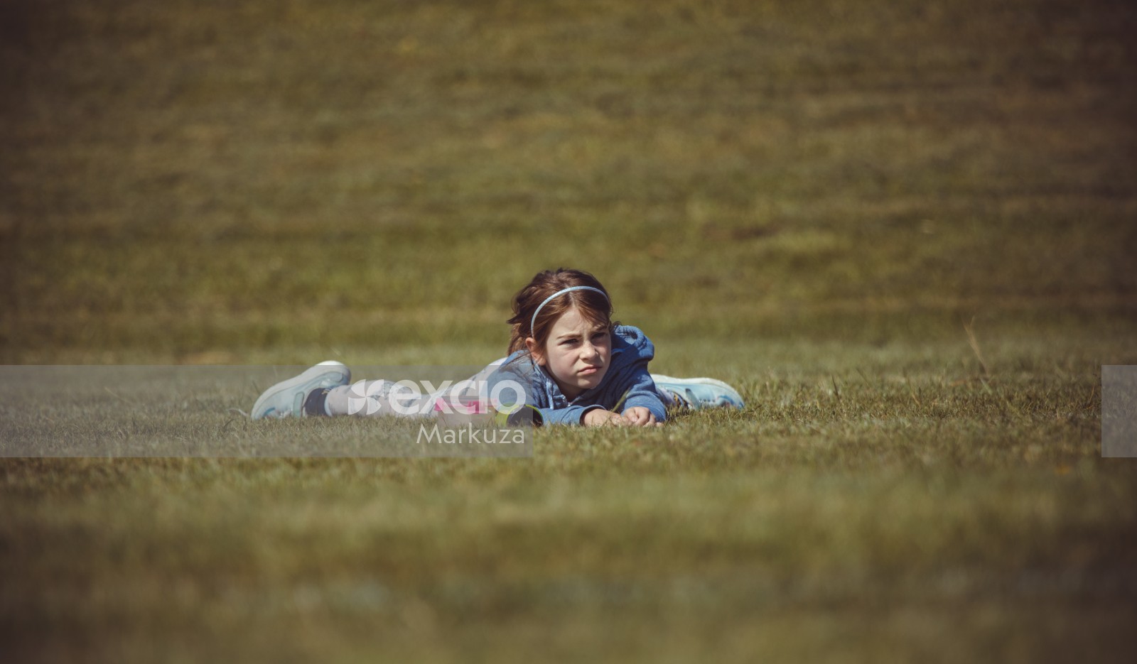 Girl laying on belly on the grass - Little Dribblers