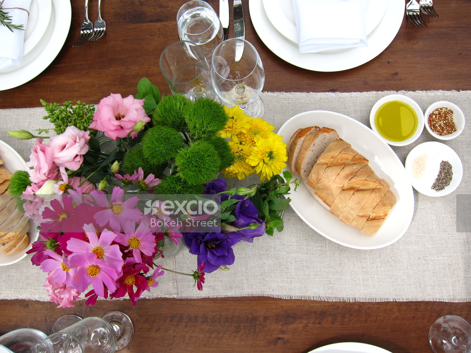 Flower vase and bread at an outdoor table setting