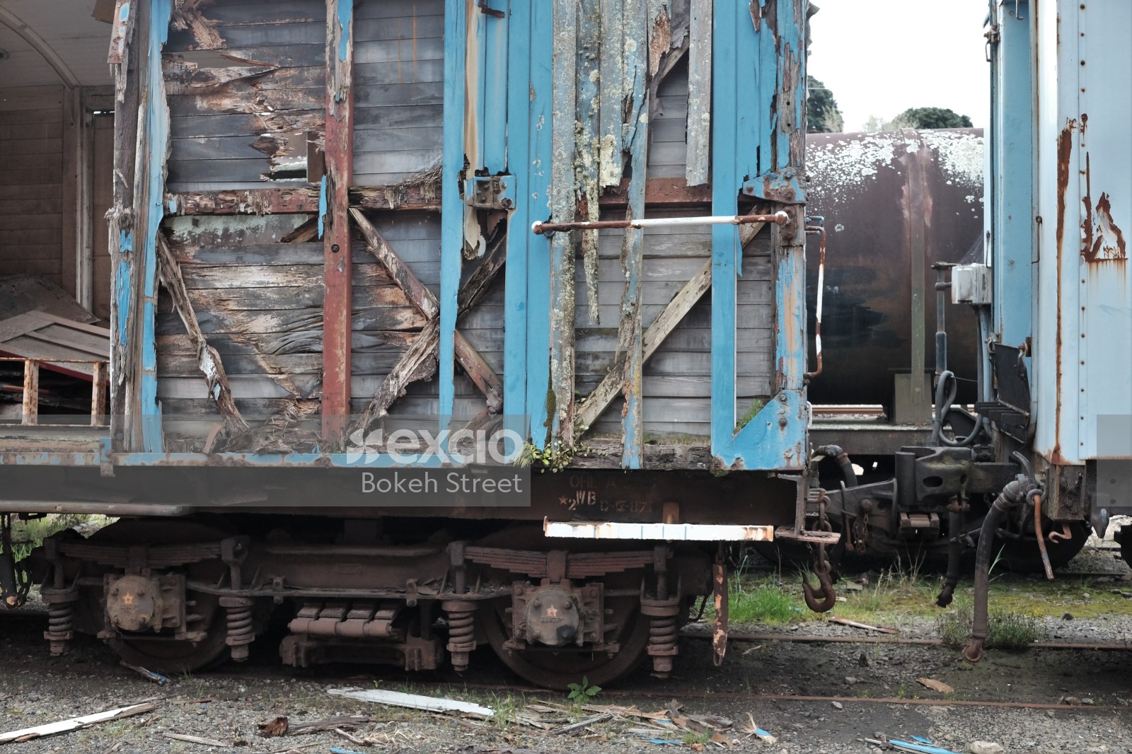 Damaged old blue freight bogie and tanker