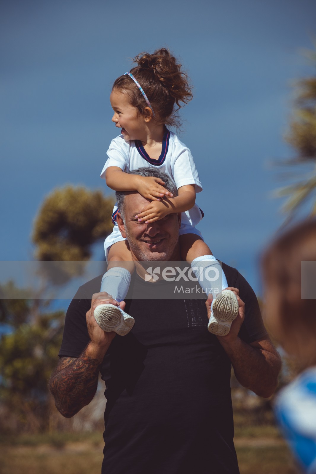 Daughter on dad's shoulders at Little Dribblers game