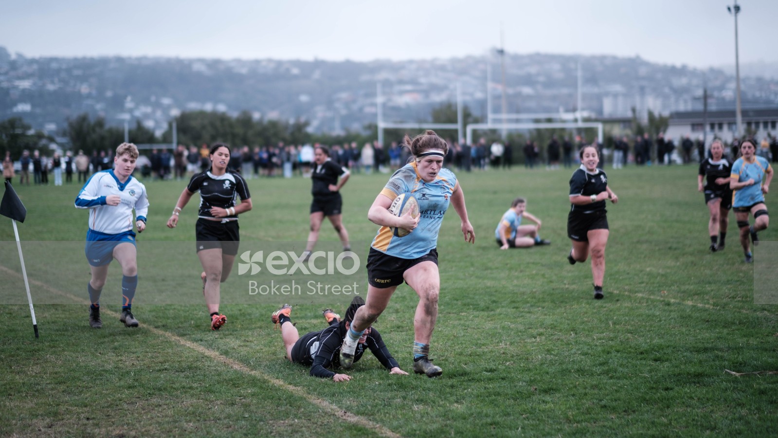Female rugby player running with ball