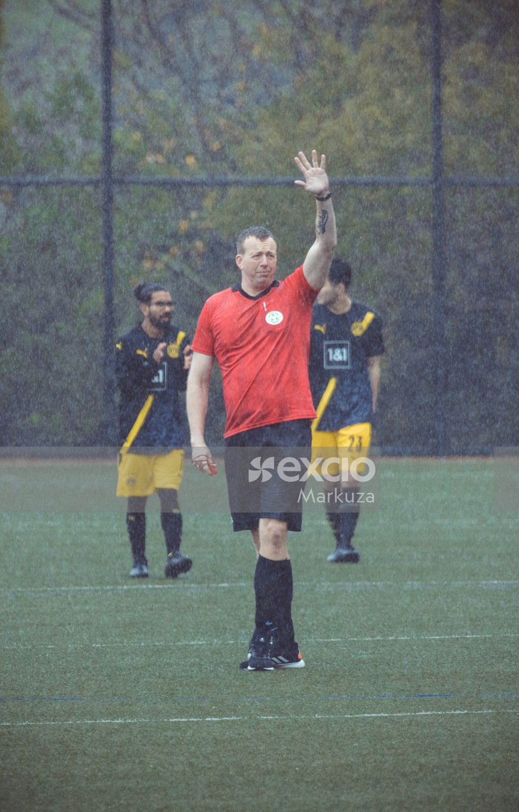 Player in red shirt raising hand in the rain - Sports Zone sunday league