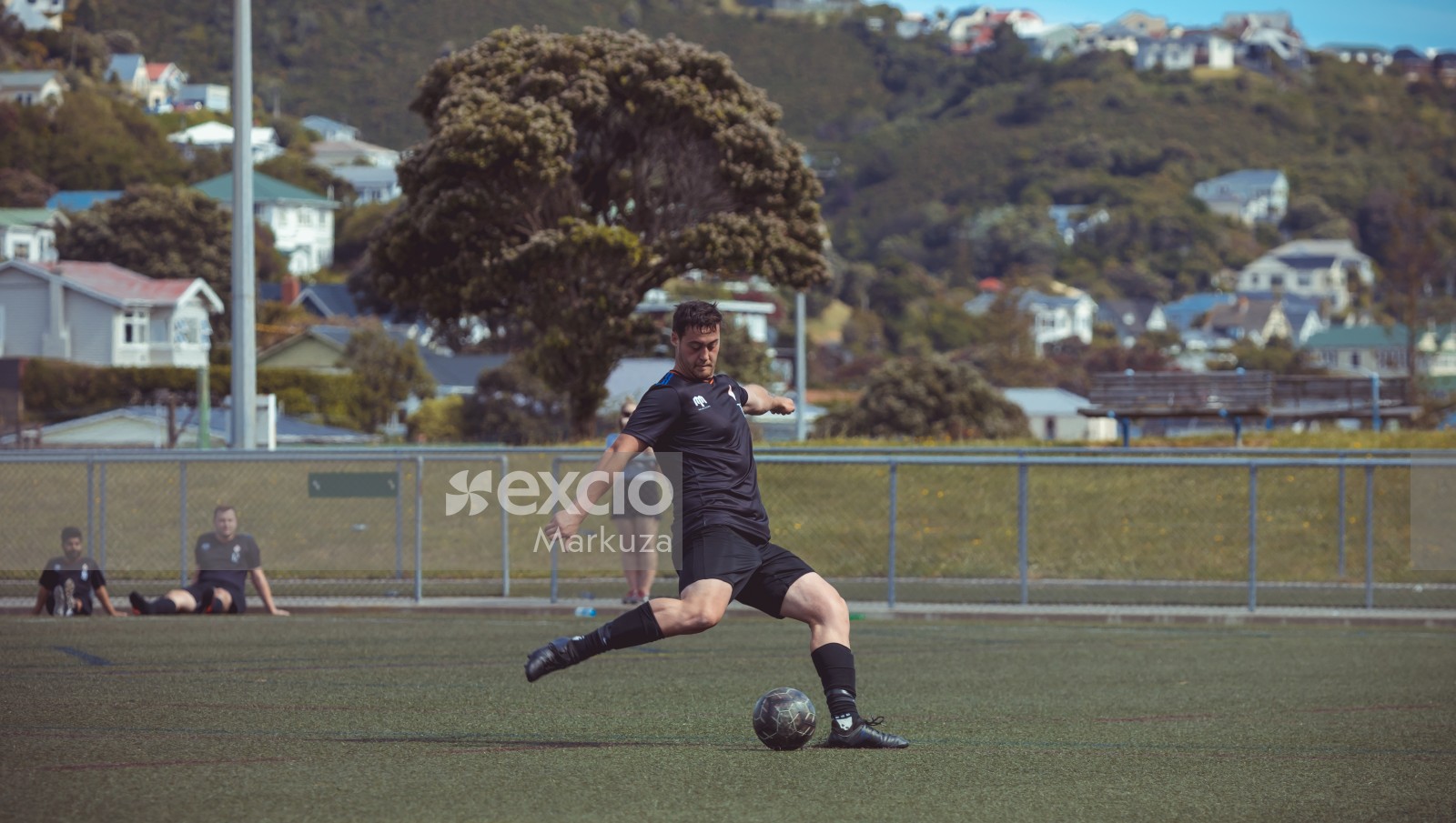 Player in black kit kicking a dark coloured football - Sports Zone sunday league