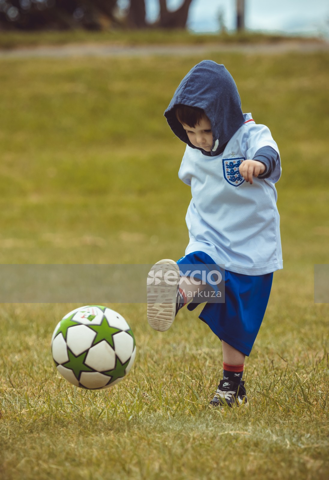 Boy in England kit kicking a football - Little Dribblers