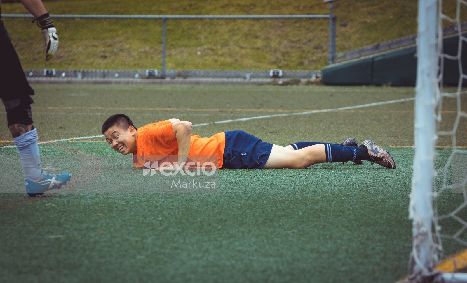 Smiling player lying on the grass - Sports Zone sunday league