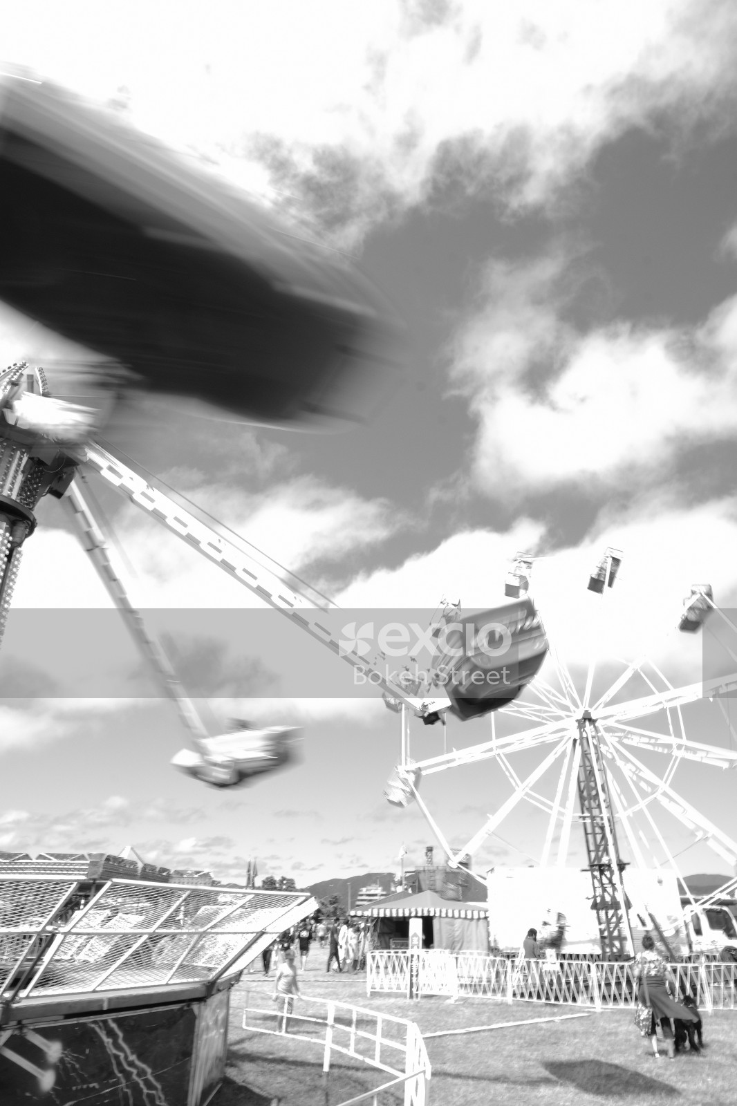 People and rides at a carnival black and white