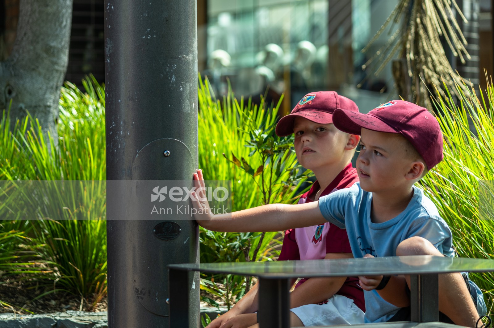 Two young boys watching a busker