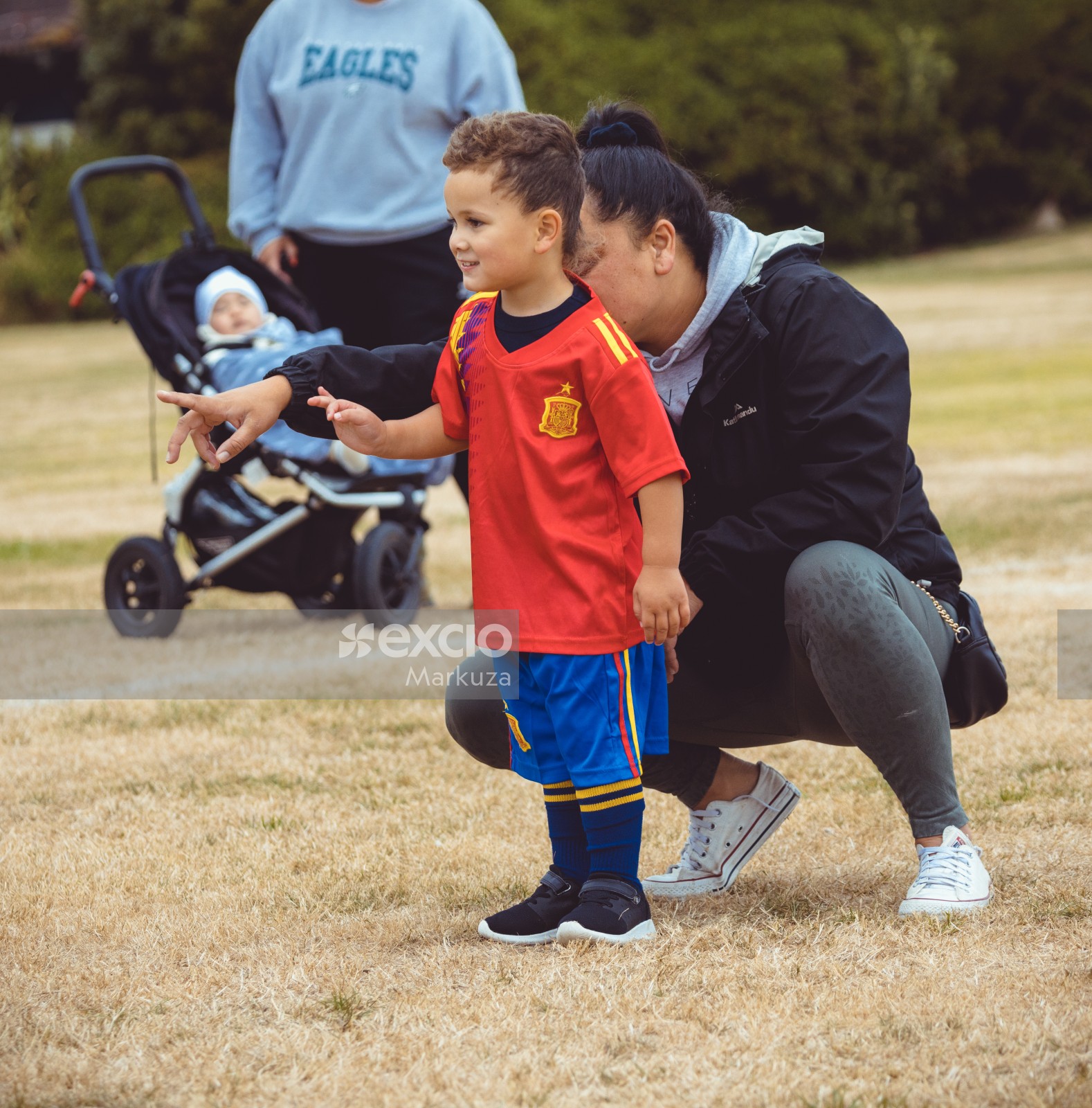 Mother pointing son towards football at Little Dribblers football competition