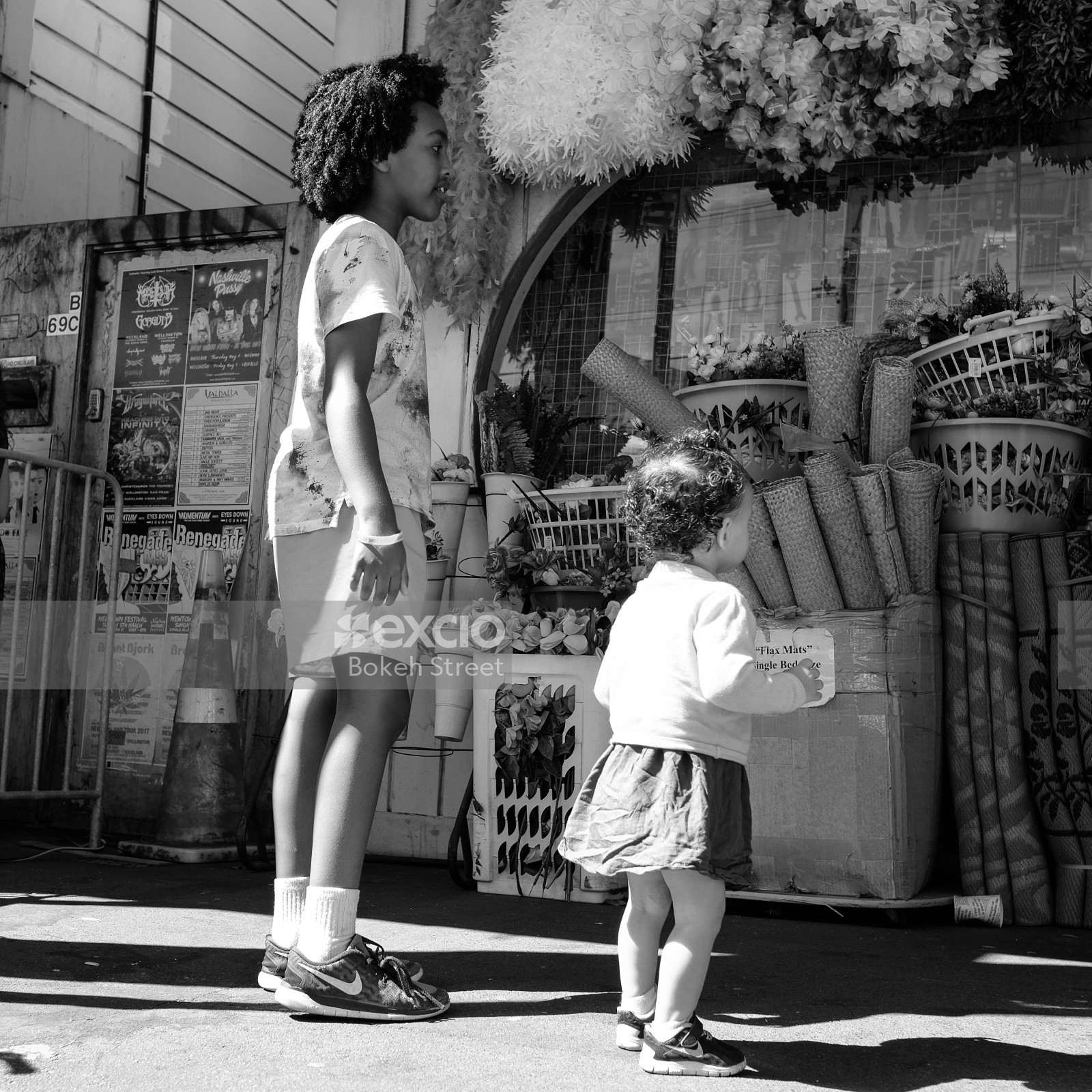 Children looking at flowers at a market black and white