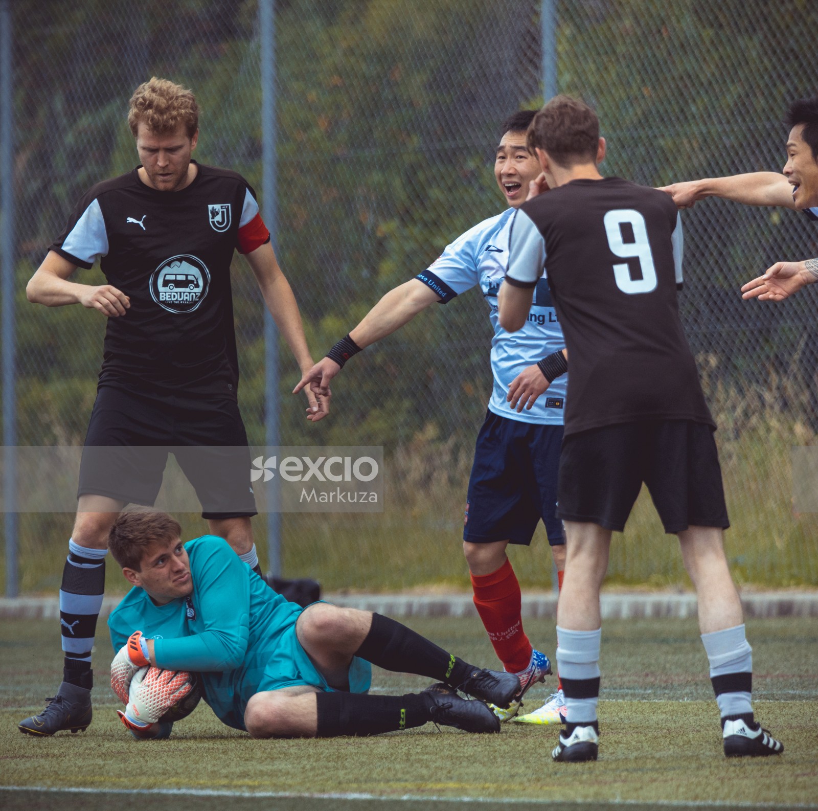 Players point at goalkeeper on the ground holding football - Sports Zone sunday league