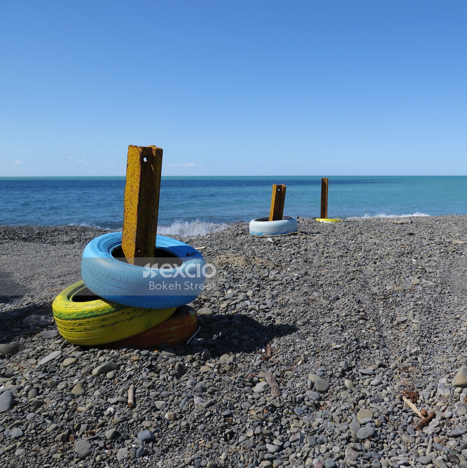Yellow metal posts on a shoreline at Hawkes bay