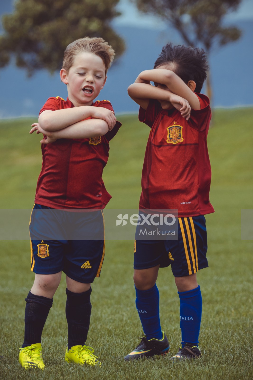 Two boys in red shirts and blue shorts at Little Dribblers football tournament