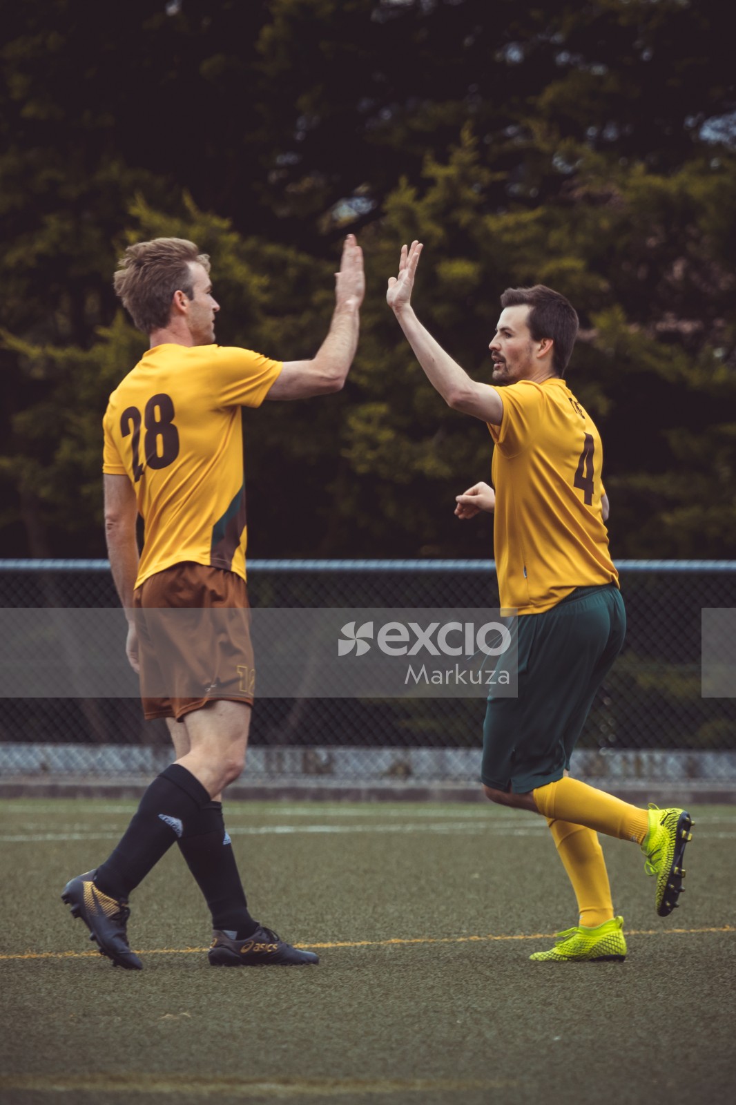 Teammates in yellow shirts high fiving - Sports Zone sunday league