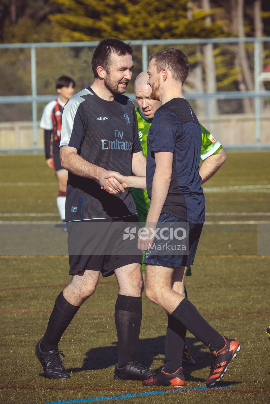 Smiling teammates shake hands at a football event - Sports Zone sunday league
