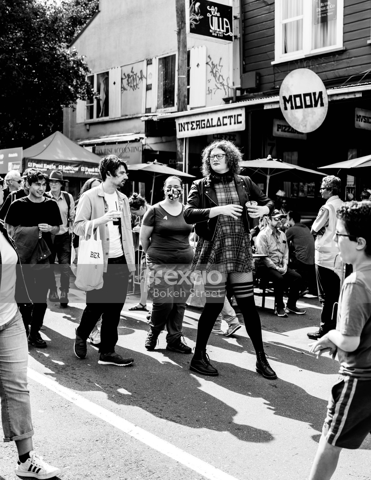 A tall curly haired woman at Newtown festival 2021 black and white