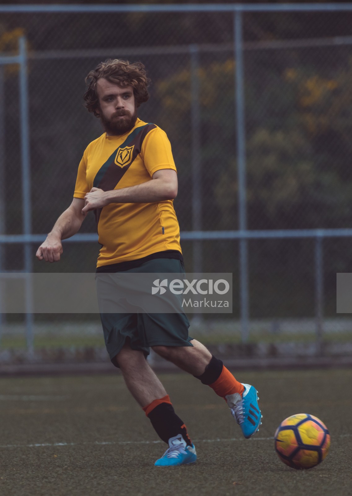 Football player with curly hair wearing yellow shirt - Sports Zone sunday league