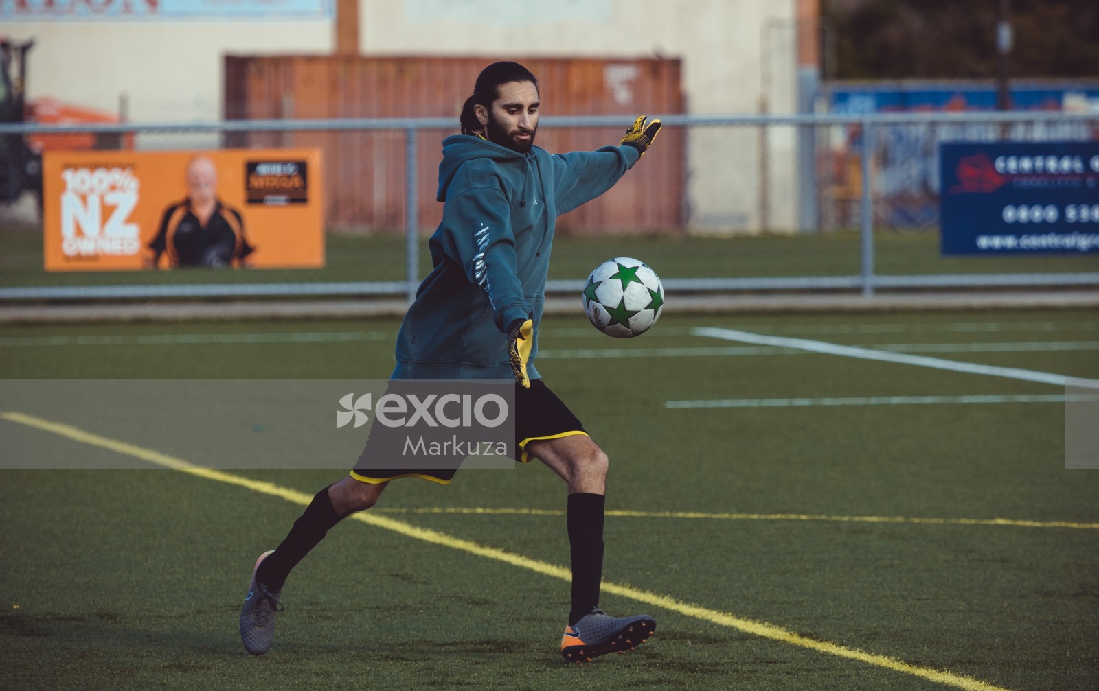 Goalkeeper with long hair and blue hoodie kicking ball - Sports Zone sunday league