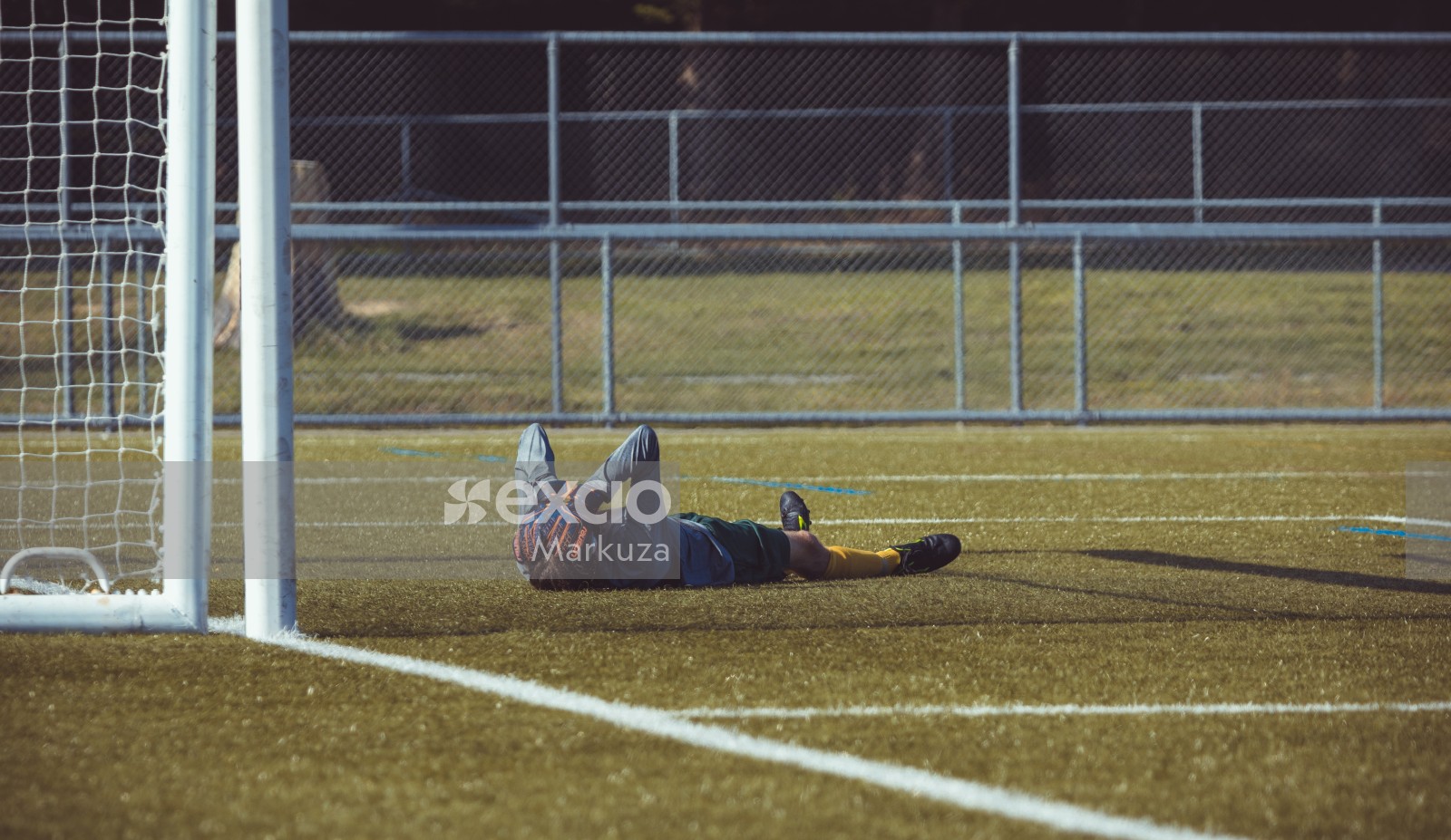 Goalkeeper covering face with hands lying on the grass - Sports Zone sunday league