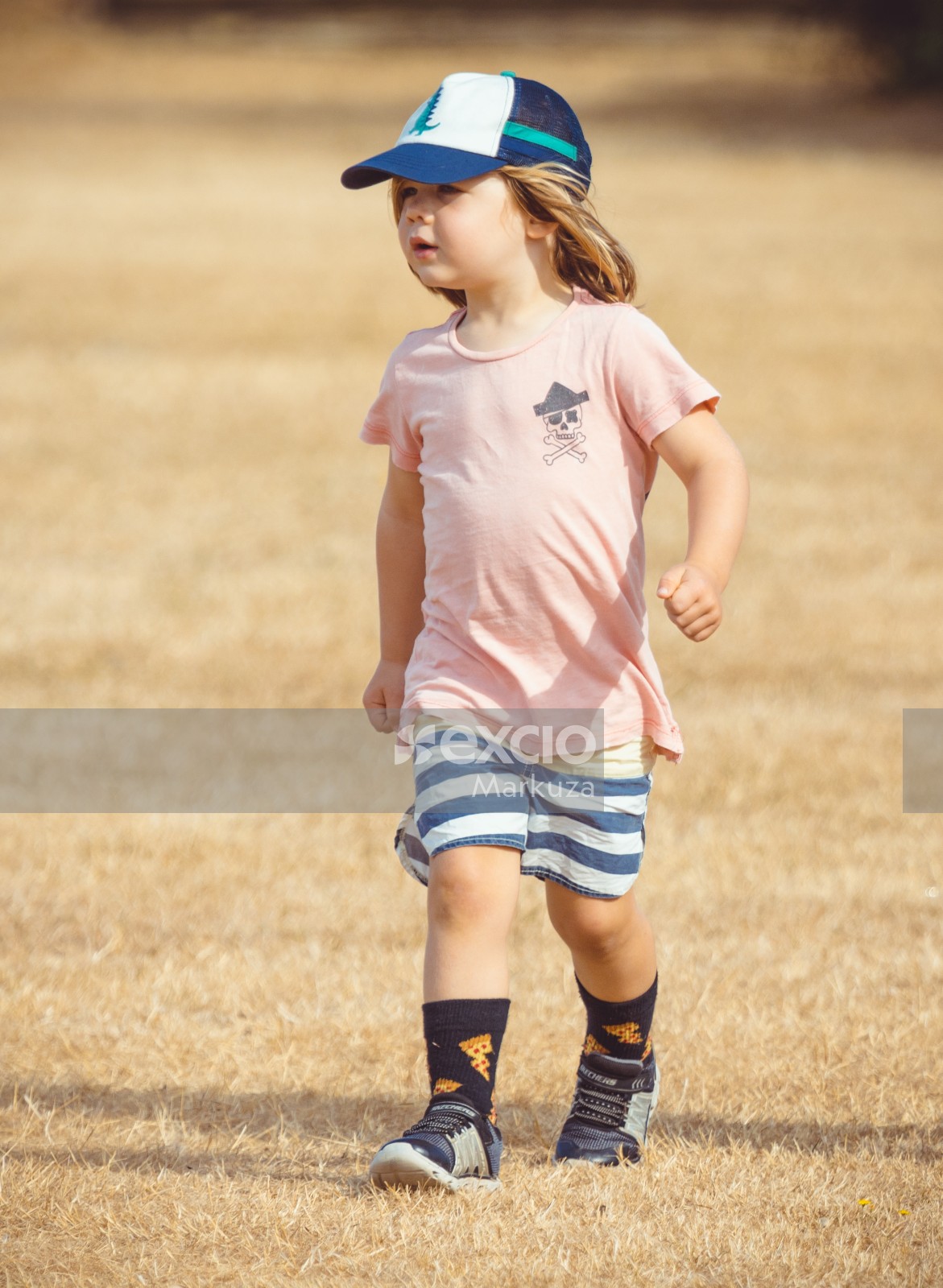 Girl wearing pink shirt with pirate symbol and striped shorts - Little Dribblers