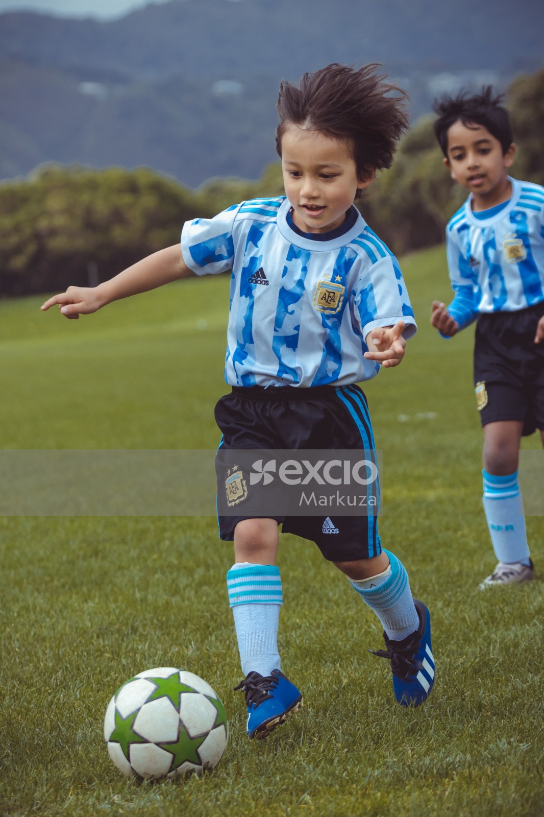 Kid dribbling football at Little Dribblers soccer bout